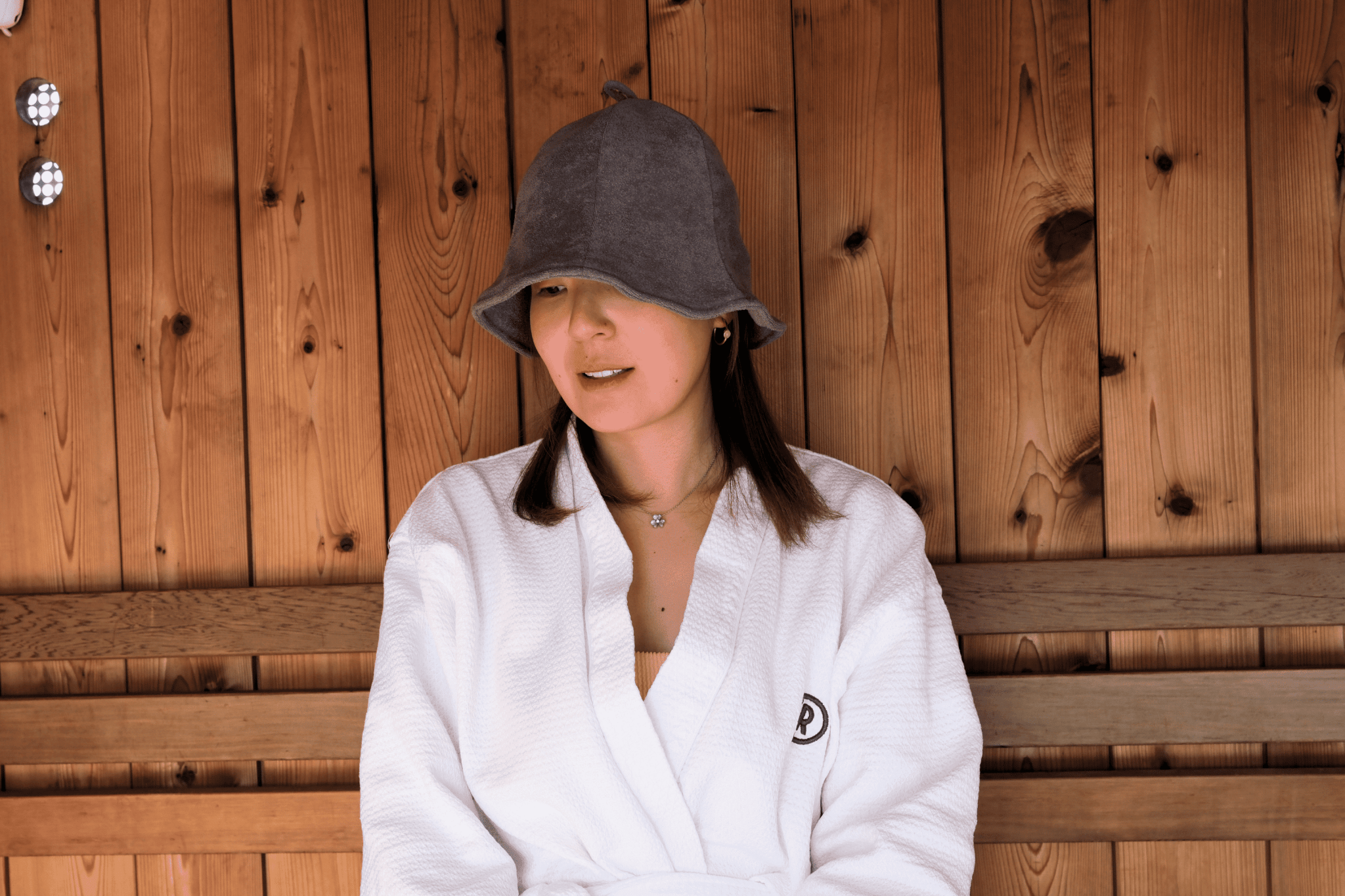 Women in sauna hat with slate grey color looking to the left